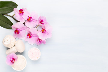 Sea salt, aromatherapy oil in bottles and orchid on vintage wooden background.
