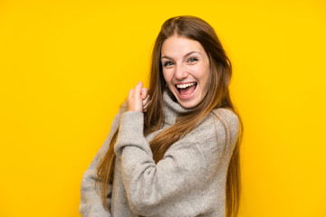 Young woman with long hair over yellow background celebrating a victory