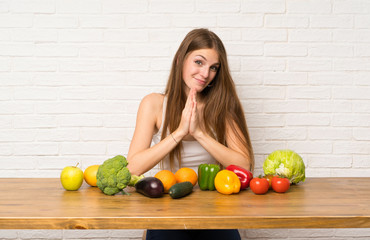 Young woman with many vegetables pleading