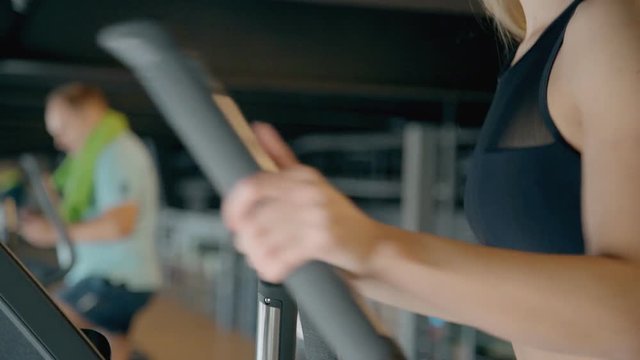 Lady making workout on orbitrek in gym