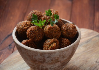 Falafel balls with parsley in wooden bowl with tahini sauce. Vegan healthy food