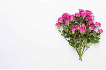 Flowers composition. Frame made of red rose on white wooden background. Flat lay, top view, copy space.