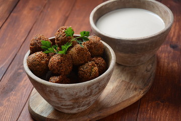 Falafel balls with parsley in wooden bowl with tahini sauce. Vegan healthy food