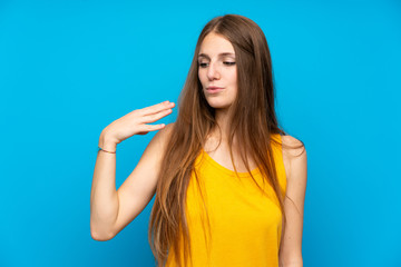 Fototapeta premium Young woman with long hair over isolated blue wall with tired and sick expression
