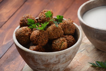 Falafel balls with parsley in wooden bowl with tahini sauce. Vegan healthy food 