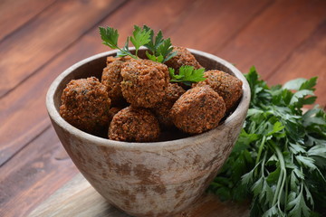 Falafel balls with parsley in wooden bowl with tahini sauce. Vegan healthy food