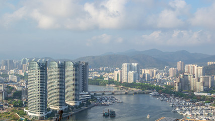 Fototapeta premium View of one of the districts of Sanya city. Visible are the skyscrapers and the public ferry terminal. Hainan Island, China.