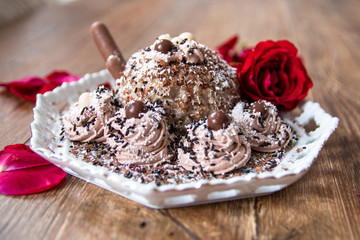 Homemade cake with cooked minced wheat and walnuts and rose flower on wooden table