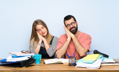 Students with many books making sleep gesture in dorable expression