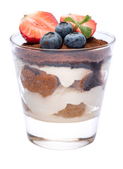 Classic tiramisu dessert with blueberries and strawberries in a glass isolated on a white background with clipping path