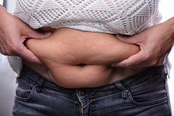 Close-up Of Woman Pinching Belly Fat