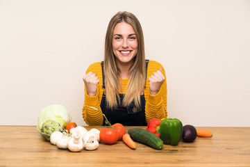 Fototapeta premium Woman with lots of vegetables celebrating a victory