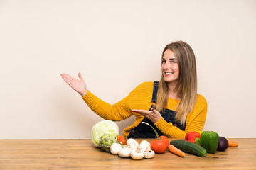 Woman with lots of vegetables extending hands to the side for inviting to come