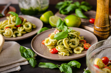 Homemade pasta with fresh basil pesto and tomatoes
