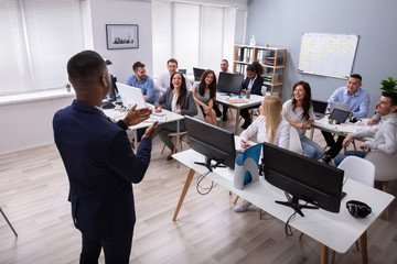 An African Businessman Giving Presentation In Office