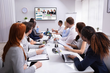 Businesspeople Having Video Conference In Boardroom