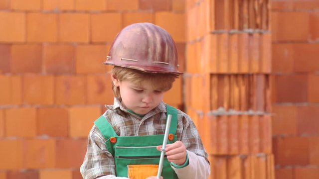 Childhood concept. Little boy dreaming about a new home. Son helper. Child and works. Cute boy building house.