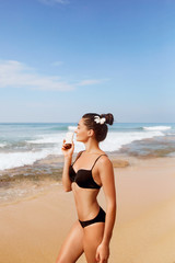 Beauty Woman in bikini. Skin care sunscreen. Portrait of Female hold bottles in her hands. Suntan. Girl applying sun cream on face.  Sun protection. Moisturizer Facial treatment.