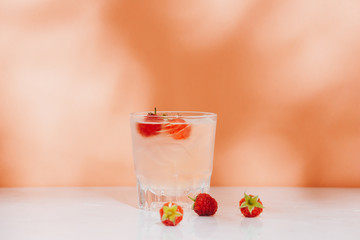 Summer juice with fresh raspberries in a glass on a light background