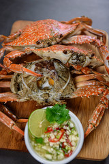 Steamed blue crab on wooden plate with spicy seafood sauce, Thai Food