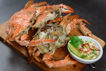 Steamed blue crab on wooden plate with spicy seafood sauce, Thai Food