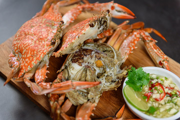 Steamed blue crab on wooden plate with spicy seafood sauce, Thai Food