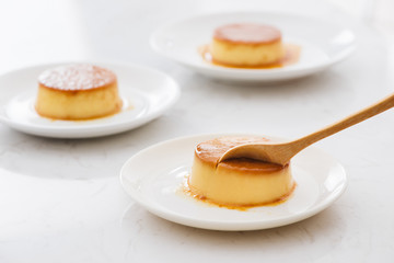 Delicious vanilla custard in caramel sauce with spoon