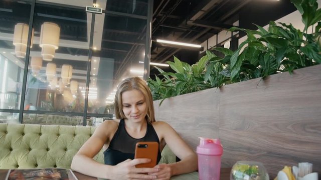 Girl making self photo on smartphone inside cafe