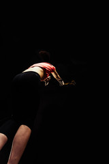 Muscular young girl doing pull-ups on rings