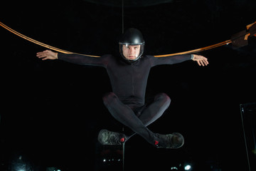 levitation in black suit in aerotube