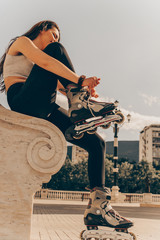 Woman preparing for roller blading, putting on rollerblades