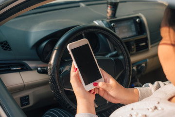 Woman driver using smart phone in car during traffic jam , blank screen for design purpose .