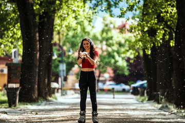 Young woman on roller skates in the summer park