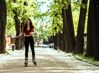 Happy joyful young woman riding roller skates in town