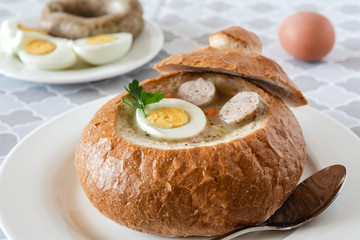 The sour soup (zurek) made of rye flour with sausage and egg served in bread bowl. Popular Easter dish.