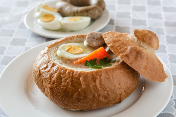 The sour soup (zurek) made of rye flour with sausage and egg served in bread bowl. Popular Easter dish.