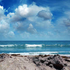 Close up seascape with sandy beach and waves on sea over cloudy sky in Deerfield Beach, Florida, USA