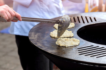 fast food on the street. potato fritters. fry on stones