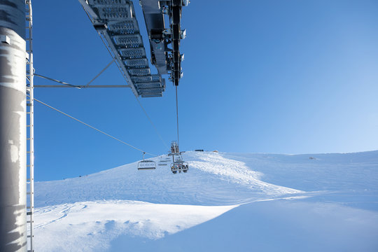 Ski lift seen from the pole against blue sky