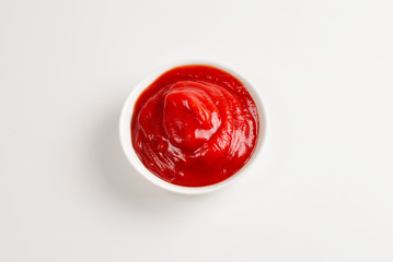 Ketchup in white plate on white background.