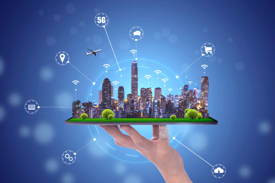 hand holding an empty digital tablet with Smart city with smart services and icons, internet of things, networks and augmented reality concept , night scape