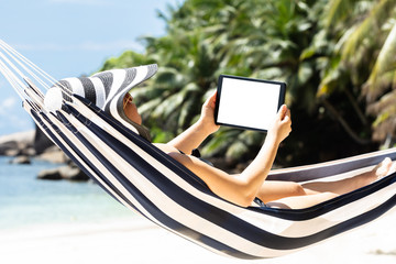 Woman Lying On Striped Hammock Using Digital Tablet