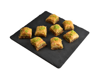 Pistachio baklava on a black plate. Dessert.
