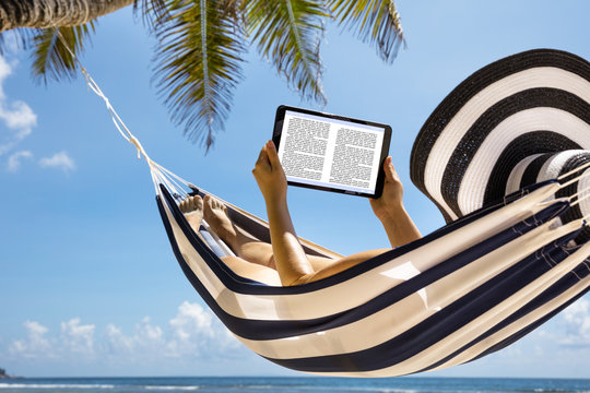 Woman In Hammock Reading The Book On Digital Tablet - Powered by Adobe