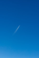 Airplane contrail against clear blue sky