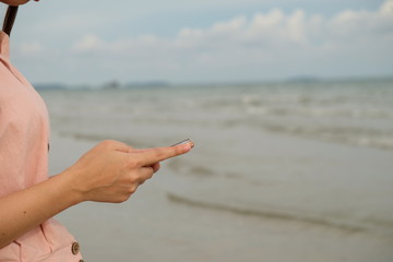 Woman used mobile phone on the beach, communication outdoor