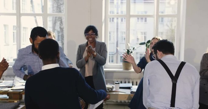 Happy multiethnic business people group dancing together celebrating holidays. Fun party at modern healthy workplace.