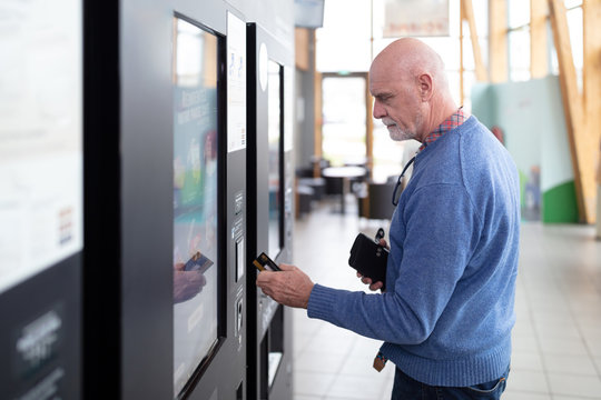Senior man paying contactless on a vending machine