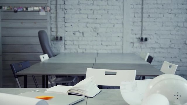 Office designer worker is sitting and preparing to work at ner architect project for manufacturing modern company.