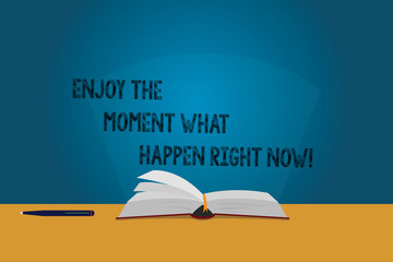 Handwriting text Enjoy The Moment What Happen Right Now. Concept meaning Seize the day Relax Leisure Color Pages of Open Book photo on Table with Pen and Light Beam Glaring